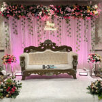 Elegant retirement function stage decoration with floral backdrop and luxury sofa in Bhopal