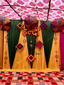 Traditional haldi ceremony decoration with yellow green drapes and ethnic umbrella decor in Bhopal