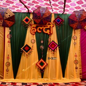 Traditional haldi ceremony decoration with yellow green drapes and ethnic umbrella decor in Bhopal
