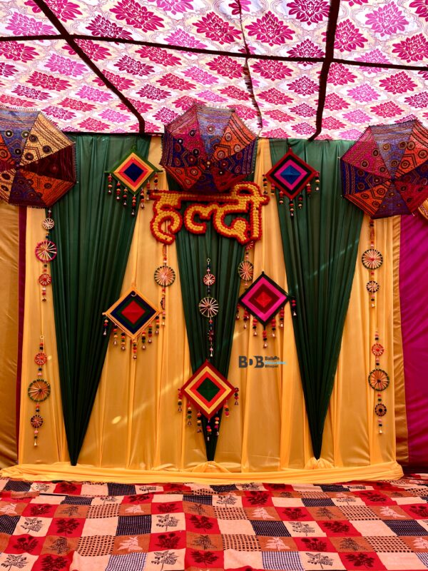 Traditional haldi ceremony decoration with yellow green drapes and ethnic umbrella decor in Bhopal