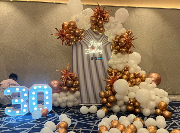 Luxury 30th birthday balloon decoration with white and rose gold balloon arch and LED numbers in Bhopal