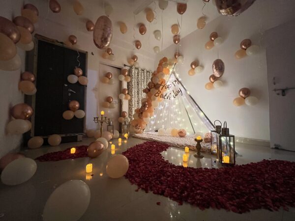 Luxury rose gold romantic couple bedroom decoration with balloons fairy lights and rose petals in Bhopal